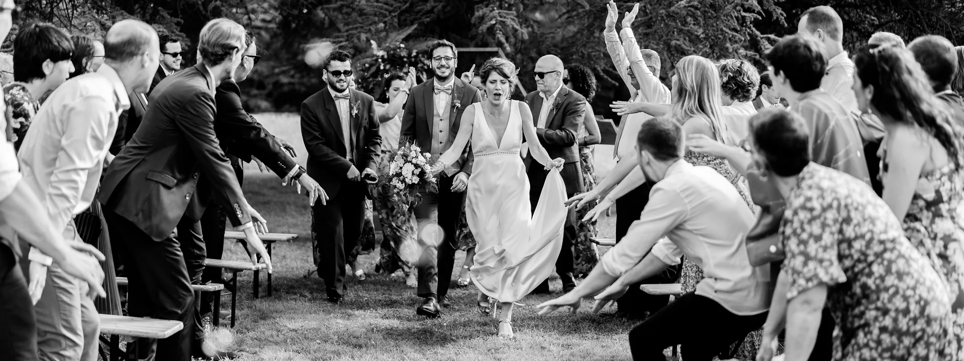 Sortie de cérémonie, les mariés courent entre les invités en liesse
