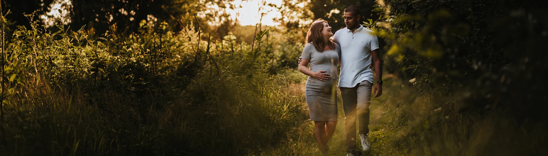 Couple attendant un enfant marchant dans un sentier au soleil couchant
